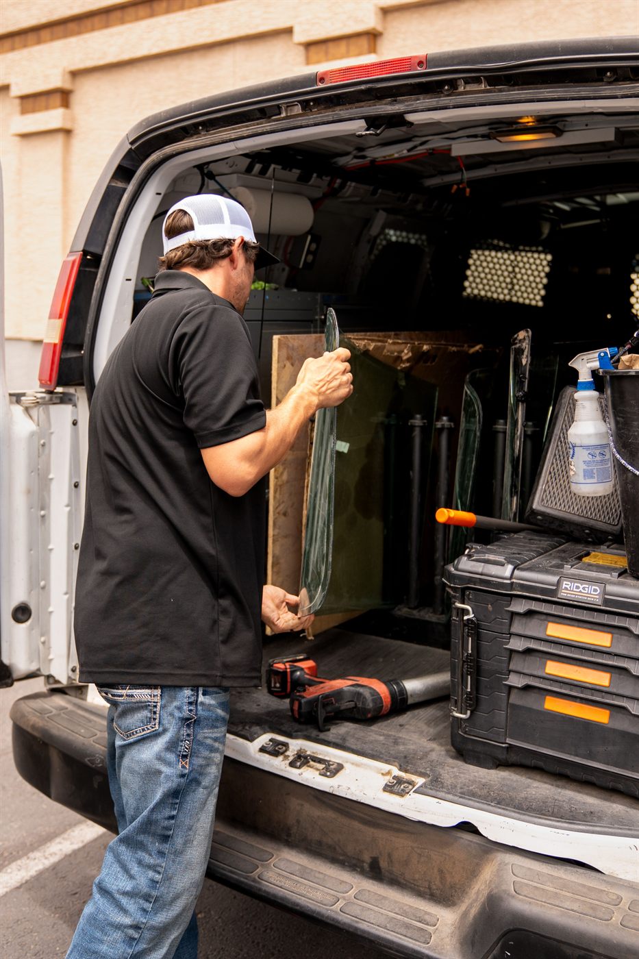 Hand loading a windshield out of the mobile glass van