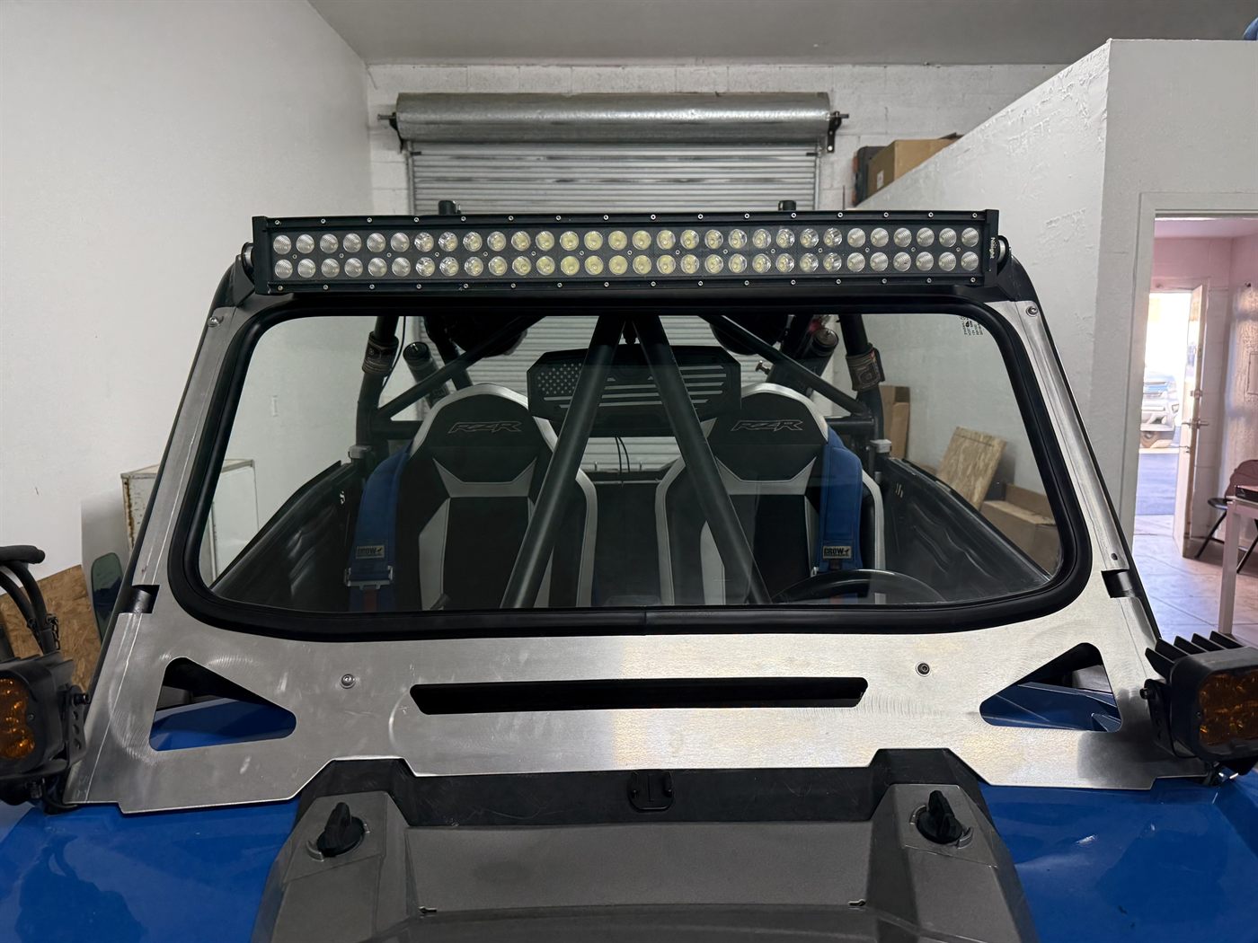 RZR side by side fitted with a new windshield and light bar